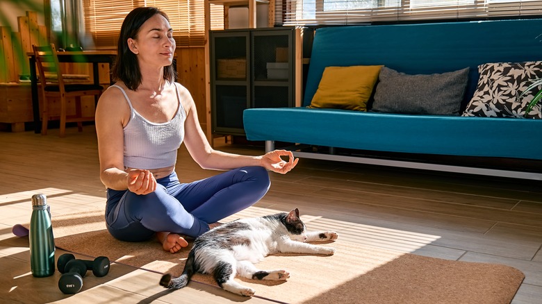 Woman meditating with her cat