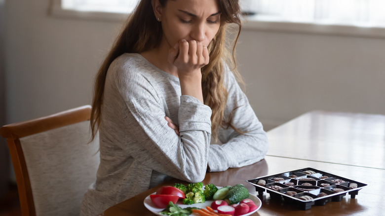 woman looking plates of food, upset