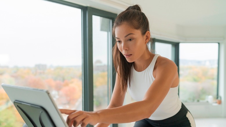 Woman using Peloton bike