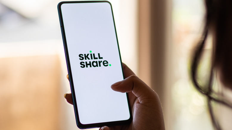 woman holding phone with Skillshare app open 