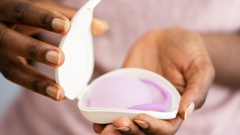 Black women holding vaginal ring