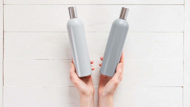 hands holding shampoo bottles