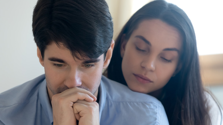 women resting chin man's shoulder