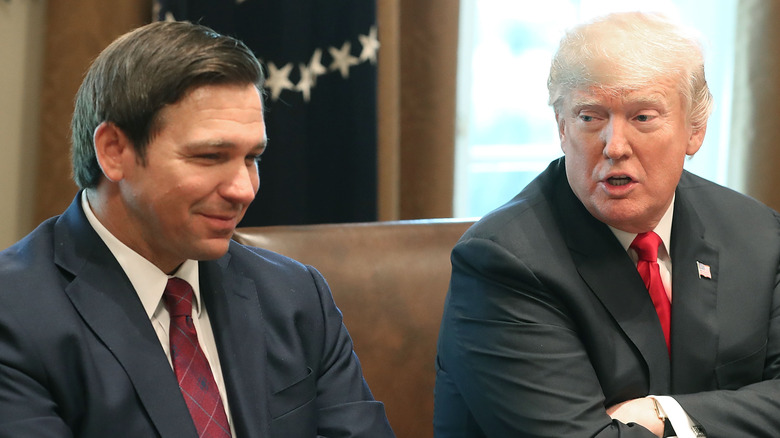 Ron DeSantis and Donald Trump sitting