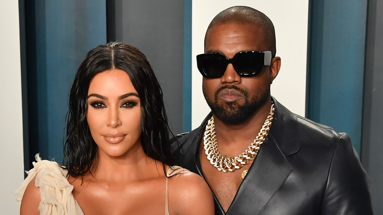 Kim Kardashian and Kanye West posing at event