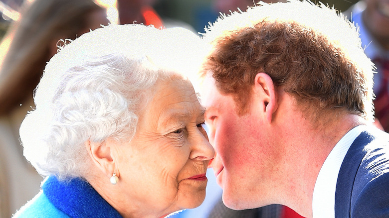 Prince Harry leans over the Queen