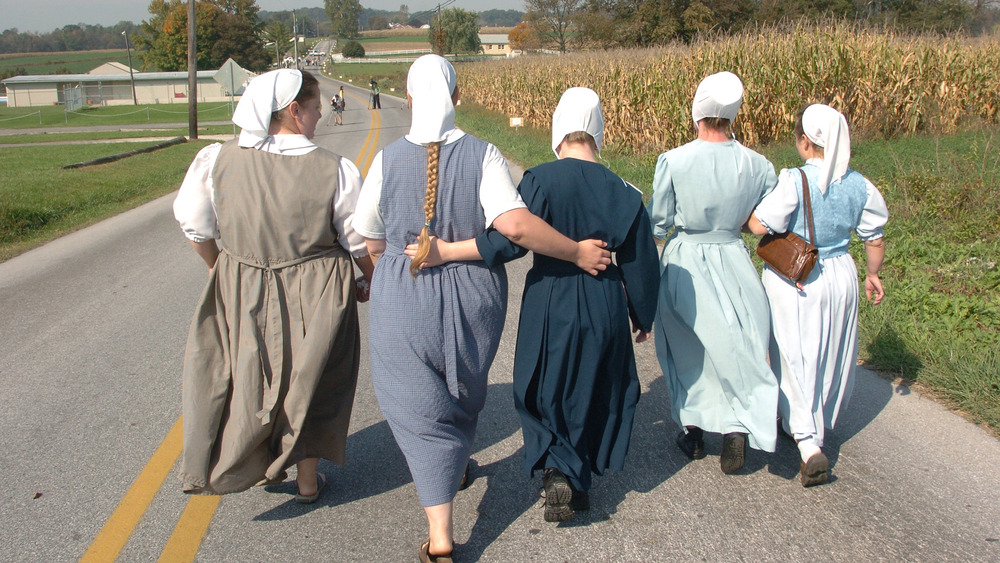 Amish women walking arm in arm 