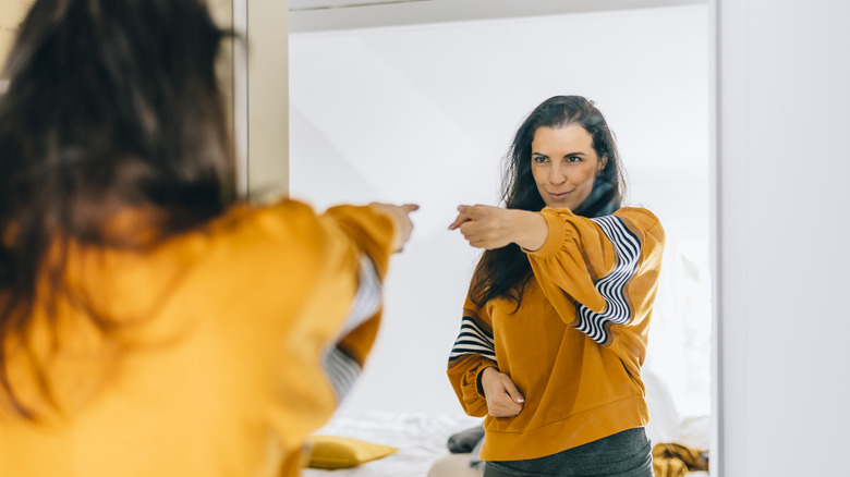 Woman point to self mirror