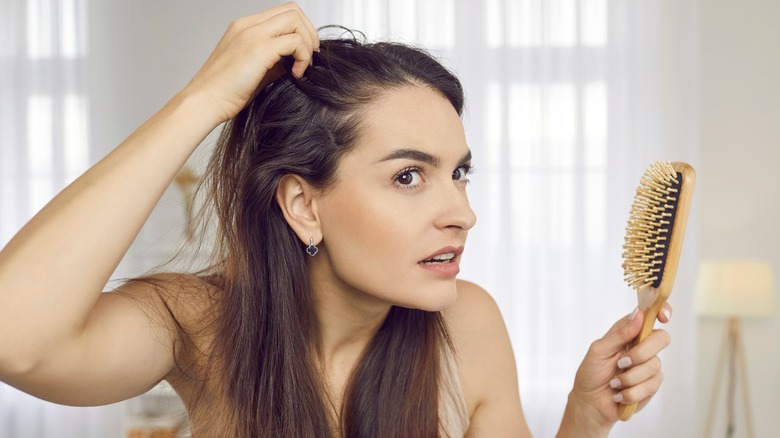 woman checking thinning hair