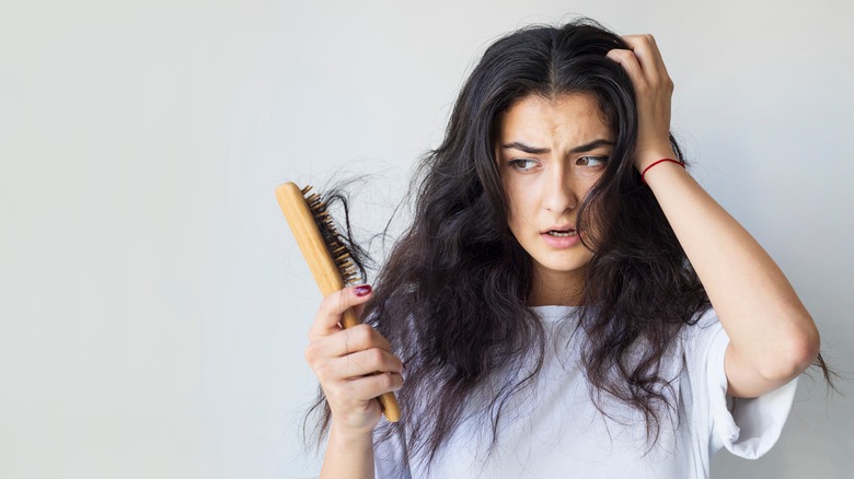 Woman with hair falling out on brush