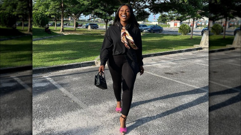 Woman wearing all black with pink heels