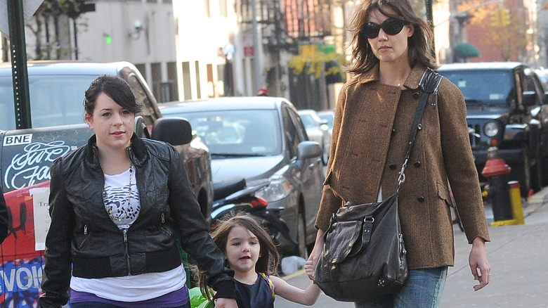 Isabella and Suri Cruise walking with Katie Holmes