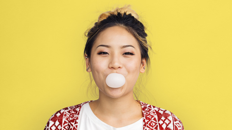 woman blowing a bubble with gum