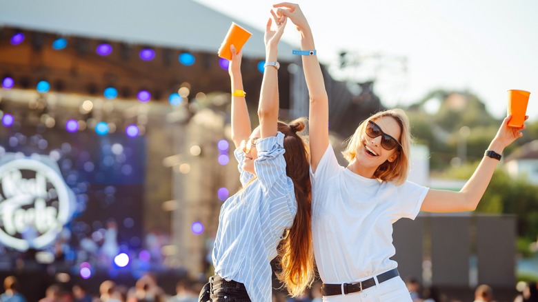 two women dance at outdoor concert