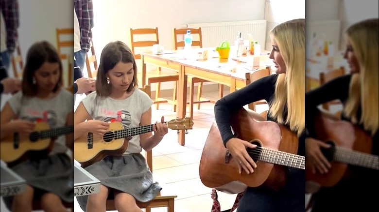 Ivanka Trump playing guitar with Ukrainian child