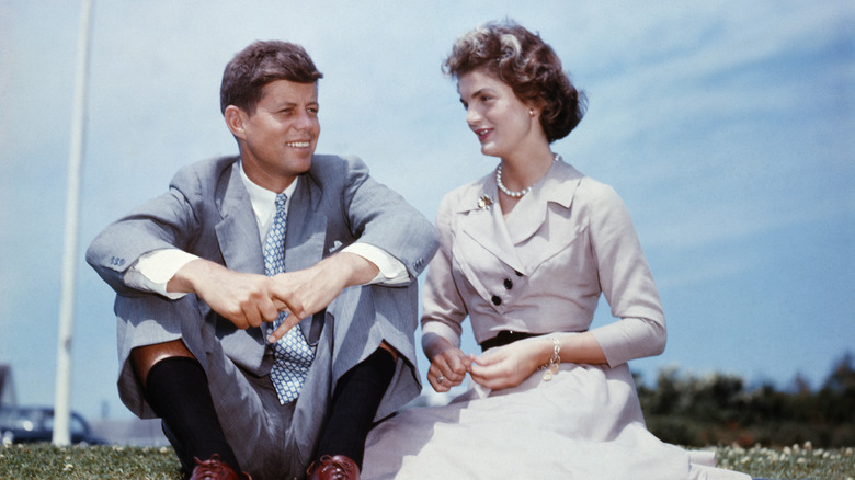 John F. Kennedy and Jackie Kennedy sit on the grass together