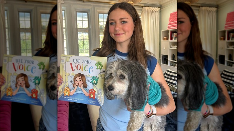 Alice Paul Tapper smiles while holding up her book "Use Your Voice"