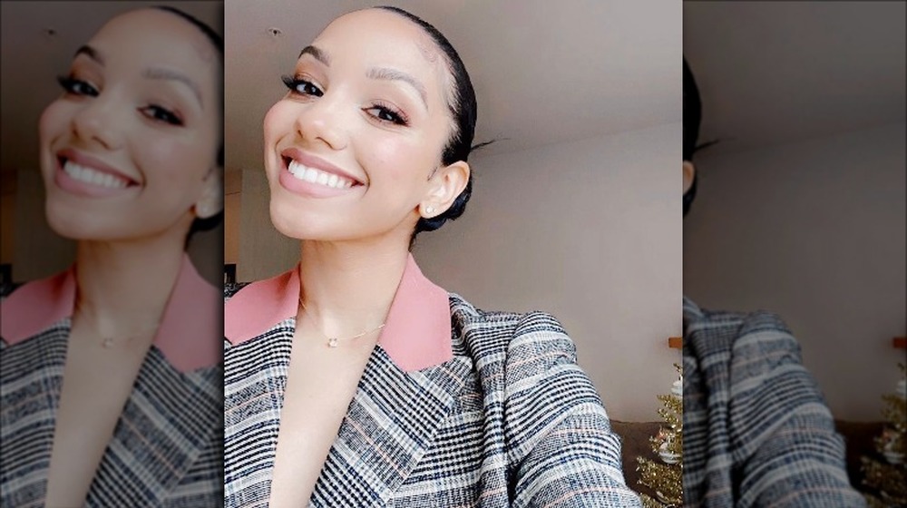 Corinne Foxx wearing a suit, smiling