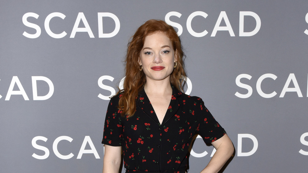 Jane Levy grinning in black and red dress