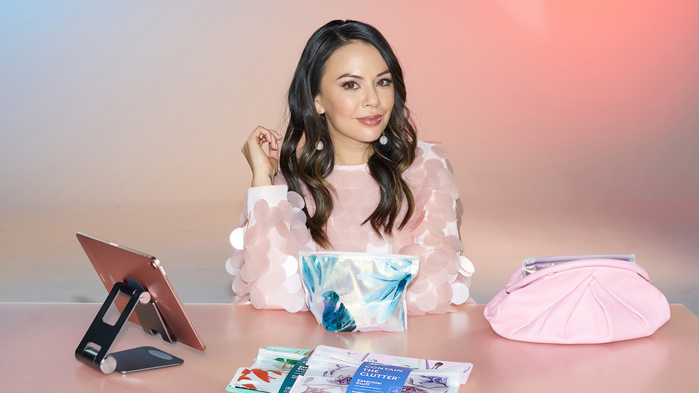 Janel Parrish sitting at a makeup table