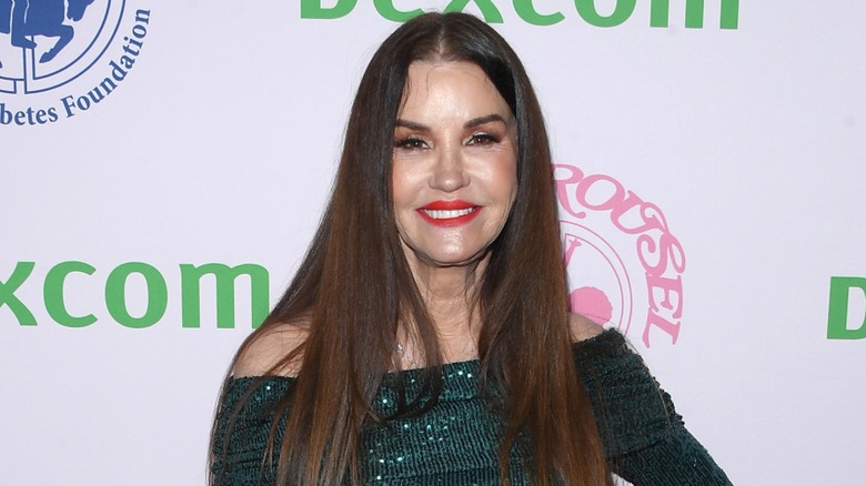 Janice Dickinson smiling in green dress