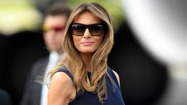 Melania Trump smirking while wearing sunglasses