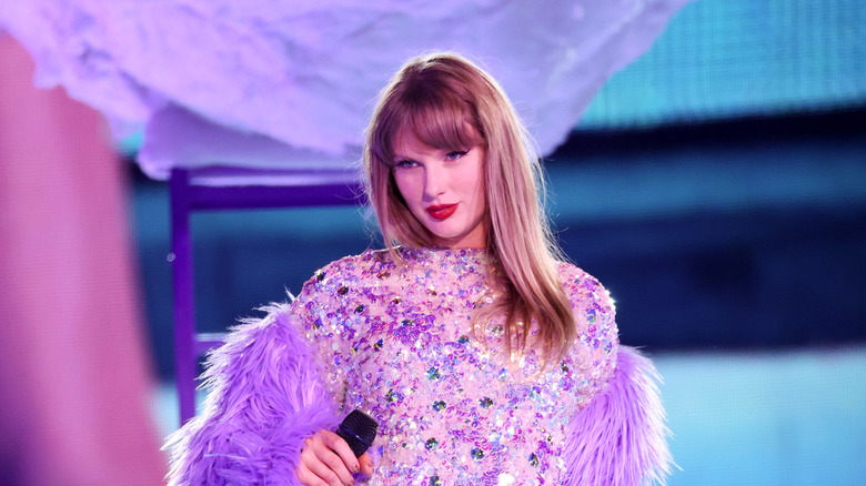 Taylor Swift posing in a sparkly purple outfit