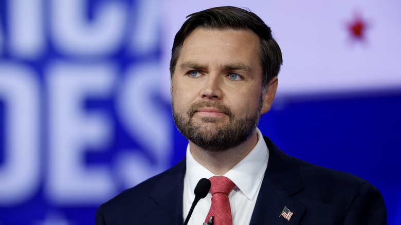 JD Vance wears an American flag pin and looks off to the side