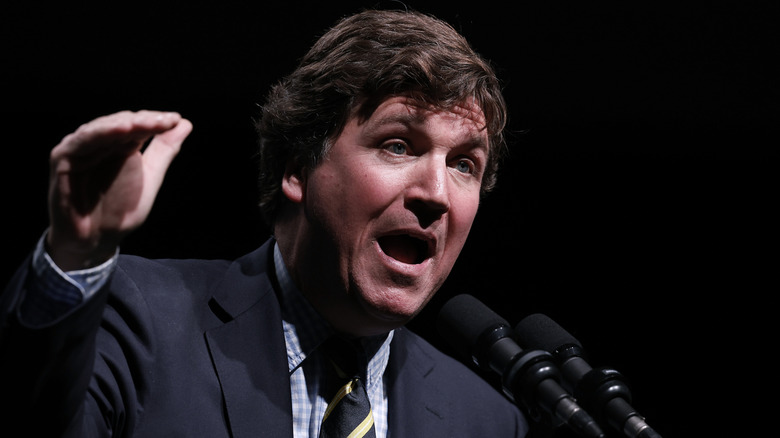 Tucker Carlson speaking at a podium