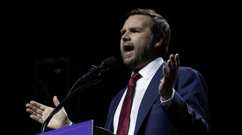 JD Vance speaking at podium with arms raised