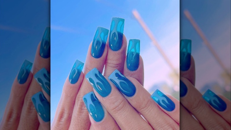 Hands showing off translucent blue flame manicure