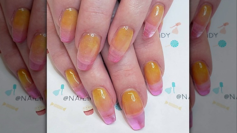 Hands with yellow and pink nail art