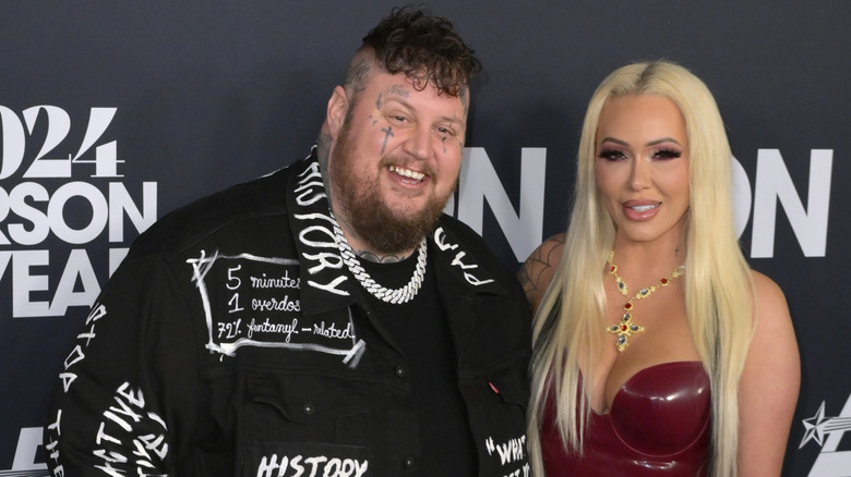 Jelly Roll and Bunny XO in a red dress pose for a picture at the MusiCares Person of the Year Gala