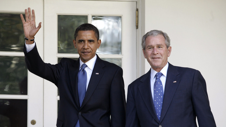 Barack Obama waves while standing next to George W. Bush