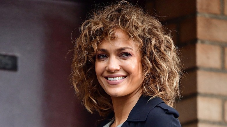 Jennifer Lopez smiling with short, curly hair