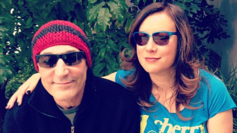 Sam Simon and Jennifer Tilly smiling in sunglasses