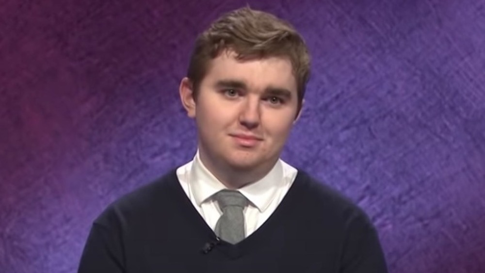 Brayden Smith head tilted in tie and blue sweater