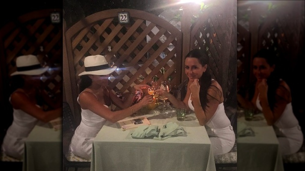 Jessica Mulroney and Meghan Markle in white hat at dinner