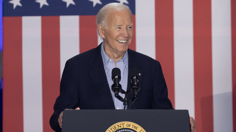 Joe Biden smiles behind a podium