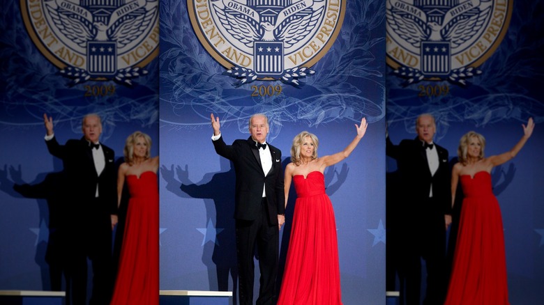 Dr. Jill Biden smiles and waves with Joe Biden on stage