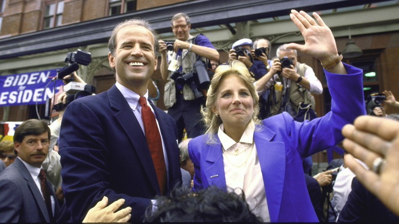 Young Joe and Jill Biden smiling and greeting crowd