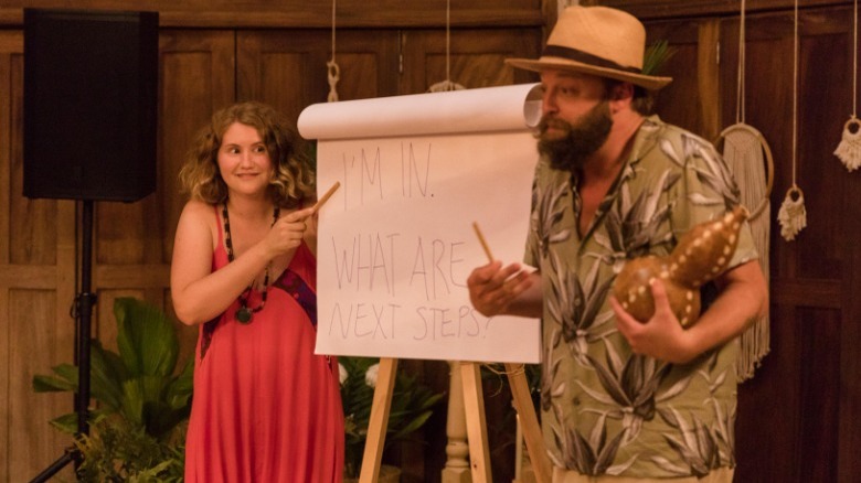 Jillian Bell and Joshua Leonard giving presentation in "The Drop"