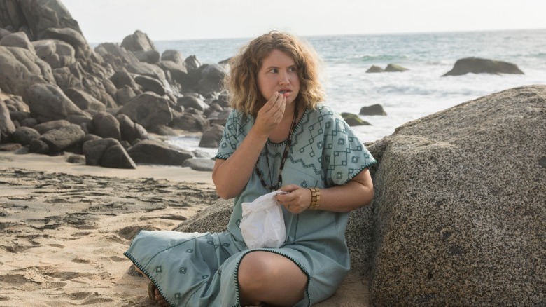 Jillian Bell eating on beach in "The Drop"