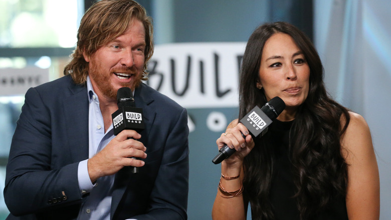 Chip and Joanna Gaines holding microphones