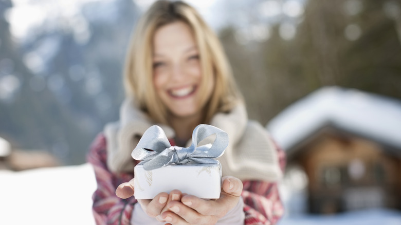 Holiday gift giving by woman in winter