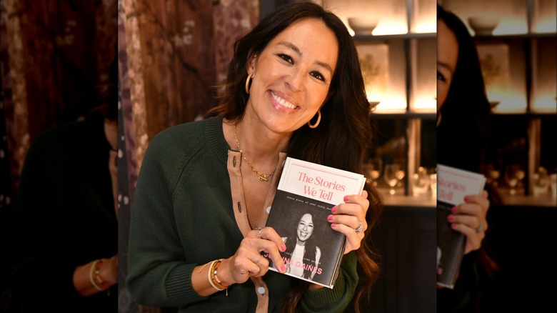 Joanna Gaines head tilt, holding book smiling