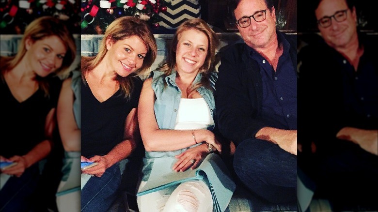 Jodie Sweetin, Candace Cameron Bure and Bob Saget sitting on a couch