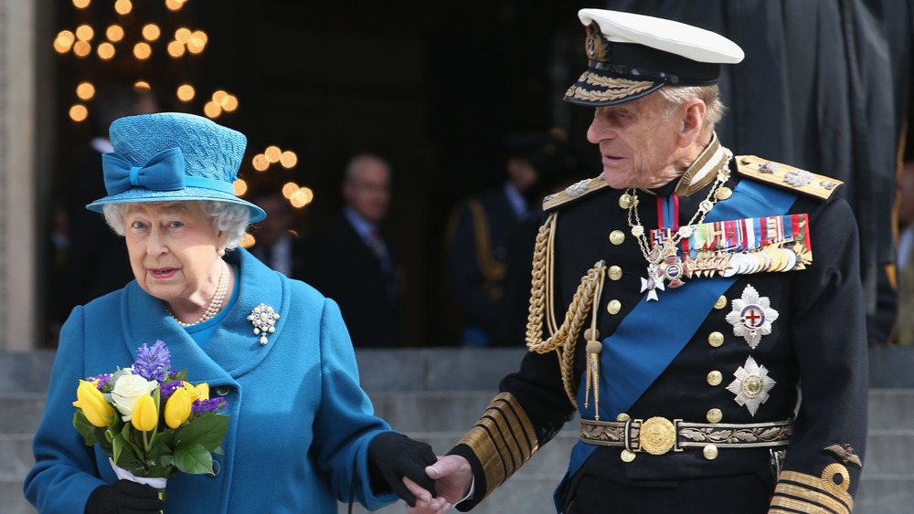 Queen Elizabeth and Prince Philip hold hands