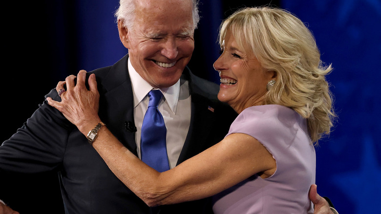 Joe Biden laughs as smiling Jill Biden puts her arm on him