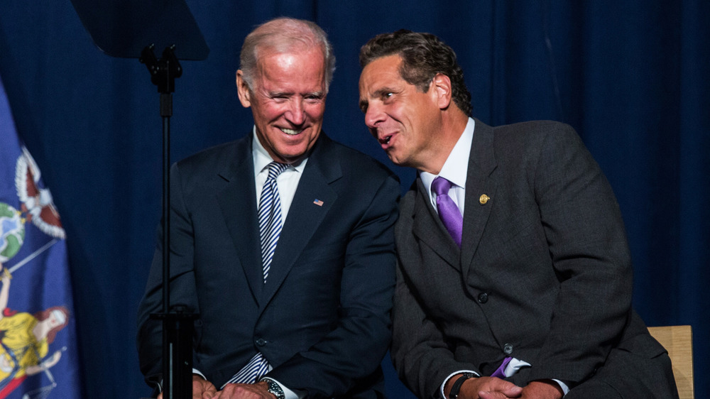 Joe Biden smiling and Andrew Cuomo leaning in talking